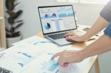 Finans ve muhasebe sektöründe çalışan iş adamları mali grafik bütçesini ve ofis odasındaki gelecek planlarını analiz ediyor. 
