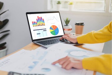 Finans ve muhasebe sektöründe çalışan iş adamları mali grafik bütçesini ve ofis odasındaki gelecek planlarını analiz ediyor. 