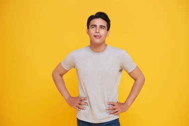 Yakışıklı Asyalı dalgın adam sarı arka planda soyutlanmış düşünüyor..