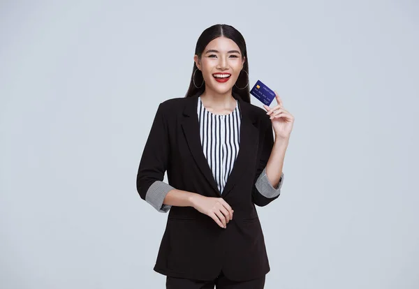 Smiling Confident Asian Business Woman Showing Credit Card Isolated Gray — стокове фото