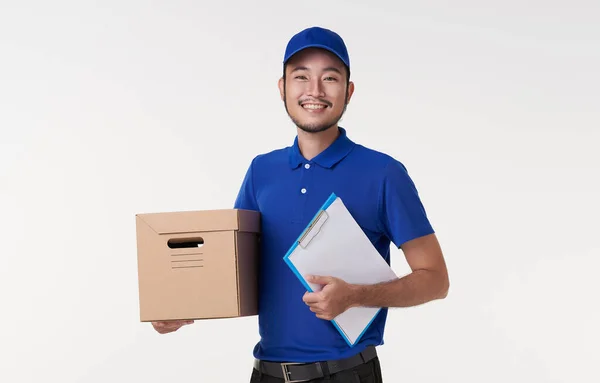 年轻快乐的亚洲送货员拿着用白色背景隔开的剪贴板和盒子 — 图库照片