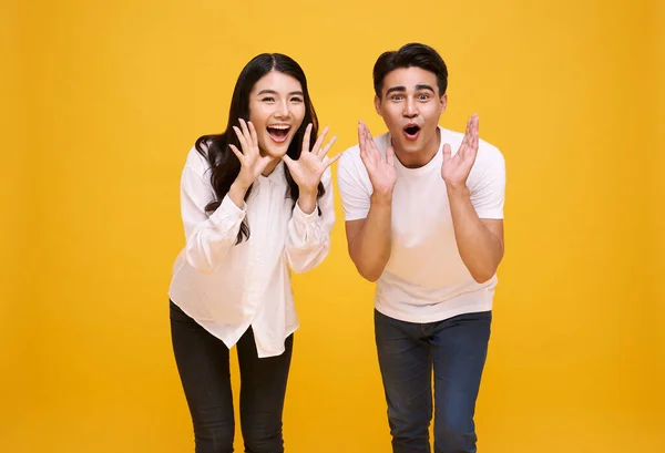 Young Asian Couple Man Woman Happy Shout Announce Yellow Background — стоковое фото
