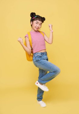 Sarı arka planda izole edilmiş Asyalı çocuk jesti mutlu kutlanır. Kazanan konsept.