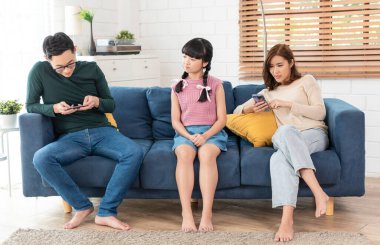 Evde tablet ve cep telefonu kullanan Asyalı bir ebeveyn. aygıtlara bağımlı, aygıtlara bağımlı aşırı kullanım.