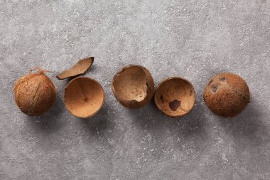 Hindistan cevizleri bir bütün ve gri betonda kırılmış.