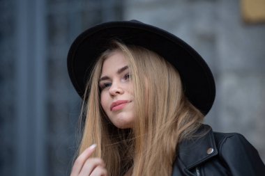 Modern şehirde şapkalı ve dönme dolaplı sarışın kız.