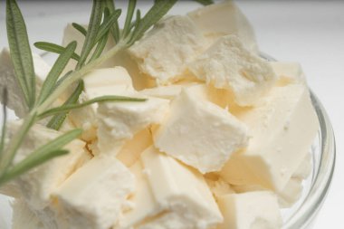 Feta peynirinin yakın çekimi şeffaf bir kasede küp şeklinde kesilmiş.