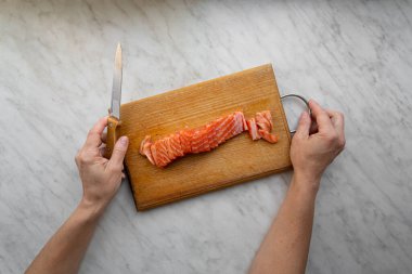 Mutfak tahtasında tuzlanmış somon doğranmış kadın.