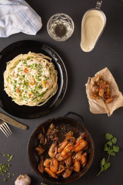 Kızarmış karides ve beyaz soslu makarna.