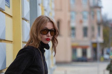 Model görünümlü bir kız eski bir Avrupa şehrinin caddesinde yürüyor. Moda gösterisi, fotoğraf çekimi..