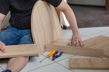 Evde kendi elleriyle mobilya montajı yapıyor.