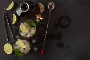 Barın arka planında rom, buz ve naneli alkollü kokteyl.