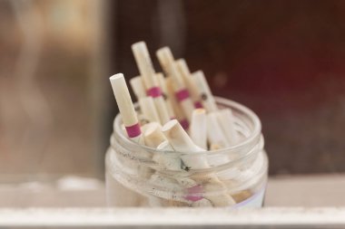 Kül tablasında sigara izmaritlerinin yakın çekimi..