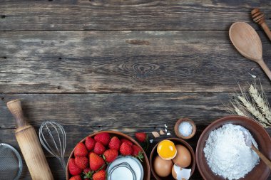 Çerçevesi çilekli turta pişirmek için yapılmış. Tahta masa, üst manzara.