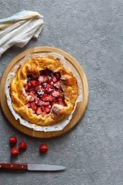 Masanın üzerine çilekli turta yakın plan. Çilekli turta açıldı..