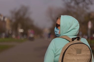 Coronavirus konsepti Hastalıktan koruyucu maske takan ve koruyucu eldiven takan kız sokakta
