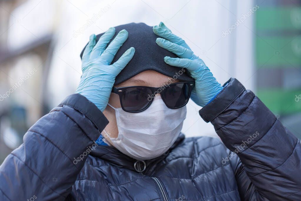 Coronavirus concept Girl wearing in a protective mask from disease and in protective gloves is on the street