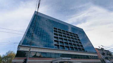 Mavi gökyüzüne bakan birçok penceresi olan çok katlı bir iş merkezi. Üçüncü dünya ülkesinde iş kavramı