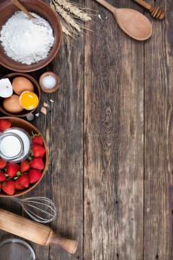 Çerçevesi çilekli turta pişirmek için yapılmış. Tahta masa, üst manzara.