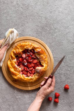 Masanın üzerine çilekli turta yakın plan. Çilekli turta açıldı..