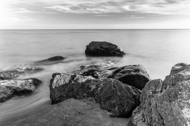 Wonderful seascape with stones on coast, B&W photo