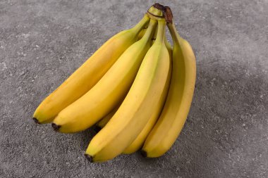 Olgun muz dalıyla gri beton üzerinde fotokopi alanı. Yakın çekim