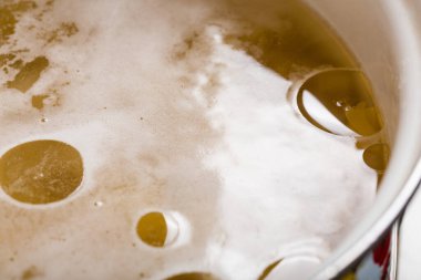 Et suyu ya da vejetaryen çorbasının yüzeyindeki bir damla bitkisel yağın yakın çekimi.