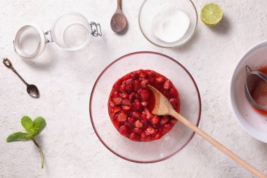 Ev mutfağında çilek reçeli yapma süreci, üst manzara.