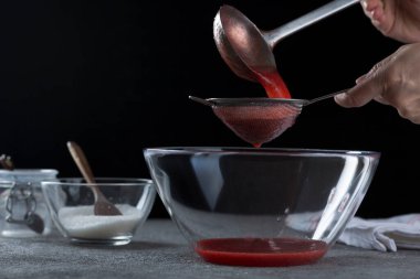 Çilek reçelini süzen kadın, ev yemeği ve yemek pişirme konsepti.