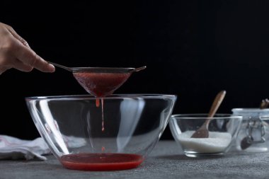 Çilek reçelini süzen kadın, ev yemeği ve yemek pişirme konsepti.