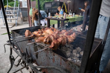 Özel bir evin arka bahçesinde yaz günü ateşte kebap ve etle barbekü pikniği..