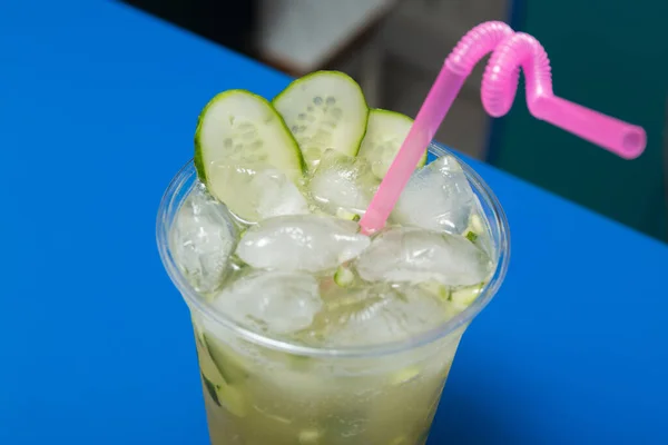 Cocktail with cucumber, lime and ice on the bar. Summer soft drink