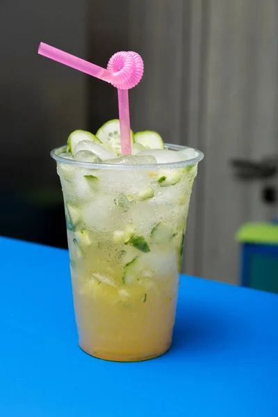 Cocktail with cucumber, lime and ice on the bar. Summer soft drink