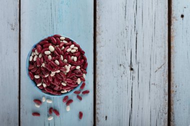 Kırmızı fasulye. Mavi ahşap arka planda, kasedeki vejetaryen yiyecekler için protein kaynağı.