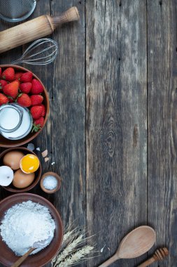 Çerçevesi çilekli turta pişirmek için yapılmış. Tahta masa, üst manzara.