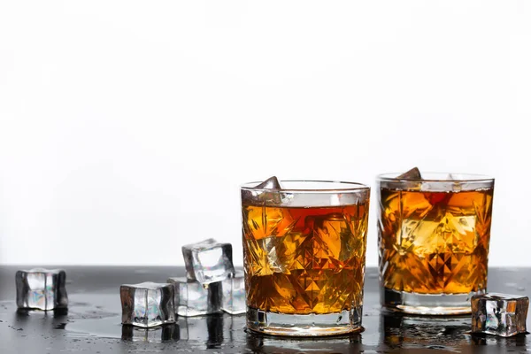 Bardakta altın viski, masada buz küpleri, üst manzara. Metin için boşluk