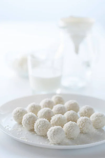 Dessert coconut cake and milk in a jug on a light background