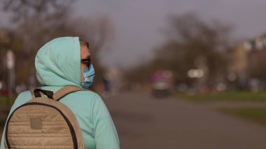 Coronavirus konsepti Hastalıktan koruyucu maske takan ve koruyucu eldiven takan kız sokakta
