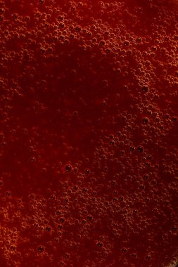 Kabarcıklı kırmızı sıvının soyut makro görüntüsü, arkaplan veya tasarım için ideal.