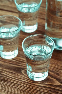 Dikey votka ve şişe kırsal ahşap masada.