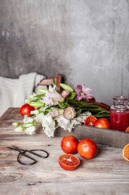 Bardakta taze kan portakal suyu, ahşap masada taze portakallar, yakın görüş.