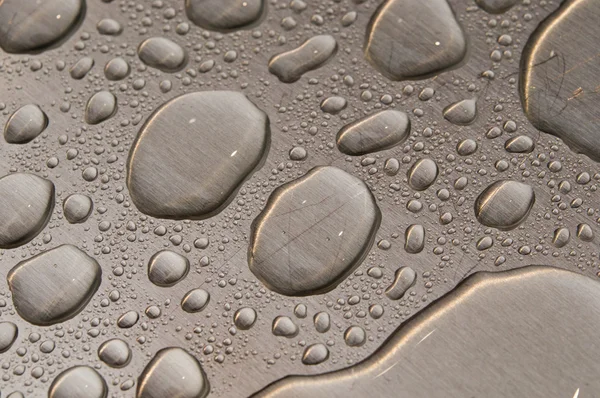 Krople wody na szczotkowanego metalu — Zdjęcie stockowe