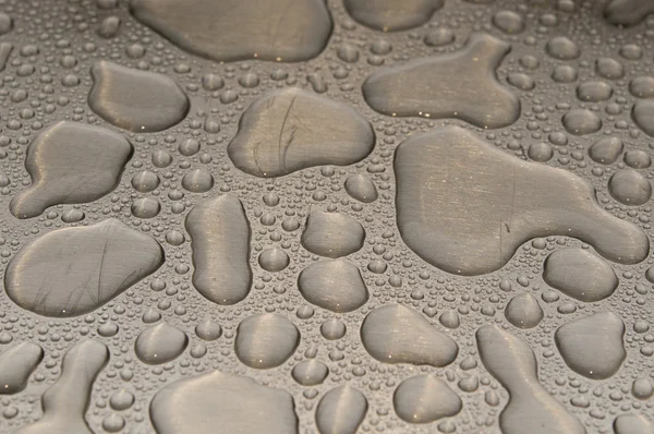 Krople wody na szczotkowanego metalu — Zdjęcie stockowe