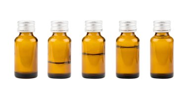 Beyaz arka planda farklı sıvı seviyelerine sahip kahverengi ilaç şişeleri koleksiyonu. Şeffaf boş ilaç şişeleri