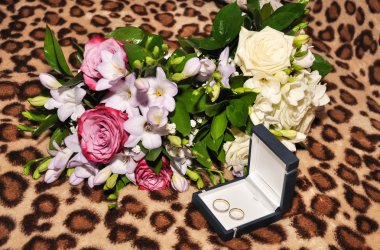 Wedding rings and two bouquets flowers.