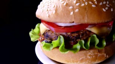 Siyah arka planda iştah açıcı bir burger. Lezzetli fast food. Hamburger ve çizburger salata ve peynirli pirzola