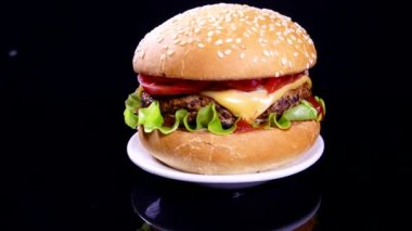 Siyah arka planda iştah açıcı bir burger. Lezzetli fast food. Hamburger ve çizburger salata ve peynirli pirzola