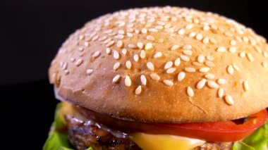 Siyah arka planda iştah açıcı bir burger. Lezzetli fast food. Hamburger ve çizburger salata ve peynirli pirzola