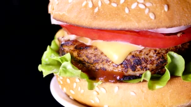 黒を背景にバーガーを食欲をそそる おいしいファーストフード ハンバーグとチーズバーガーにサラダとチーズカツ — ストック動画