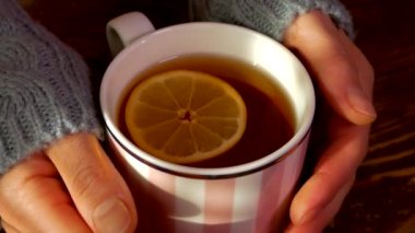 Limonlu sıcak çay. Avuçlarınızı sıcak bir içecekle bardakta ısıtın. Soğuk tedavi.